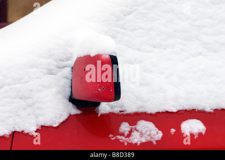 Sidemirror and car door covered with snow detail view. Stock Photo