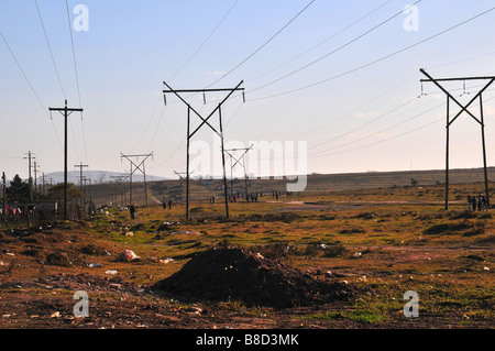 Electricity transmission lines crossing the open land around the townships of Grahamstown, South Africa Stock Photo