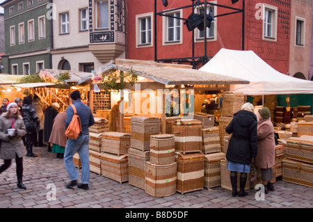 Food stands on Old Market Square, Poznan, Poland, with traditional woven baskets and people shopping during a winter market fair. Stock Photo