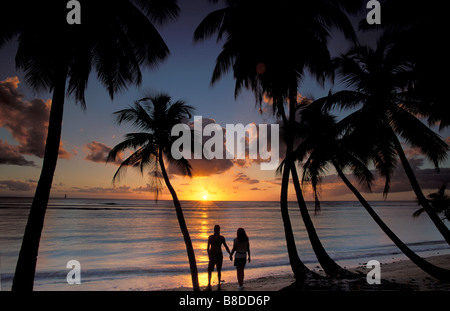 couple on beach at Sunset, Pigeon Point, Tobago Stock Photo