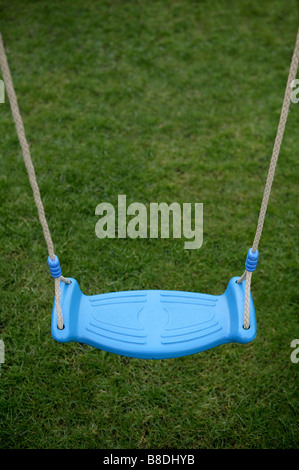 a child's swing seat in Blue with rope forming a pleasing boarder offering concepts of bravery adventure and childhood play. Stock Photo