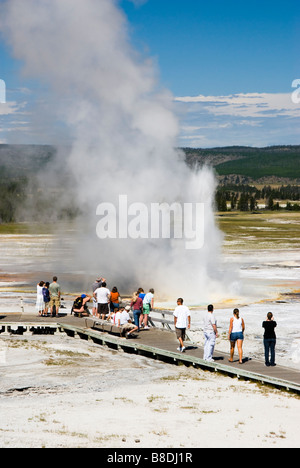 tourists watching the Clepsydra geyser on the Fountain Paint Pot Trail in Yellowstone National Park Stock Photo