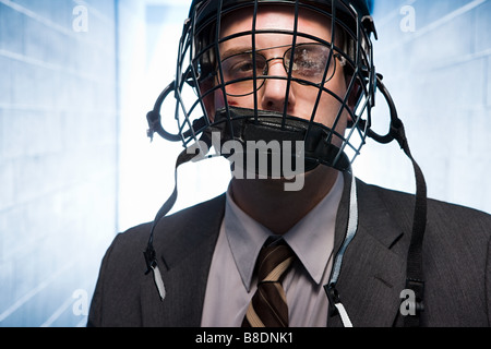 Injured businessman wearing an ice hockey helmet Stock Photo