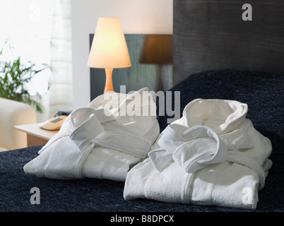 Folded bathrobes on a hotel bed Stock Photo