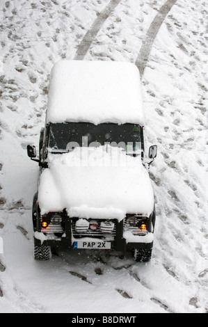 Snow covers a Land Rover Defender 90 on Brighton beach East Sussex UK Stock Photo