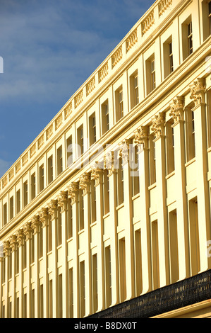 The front of Regency style properties glow in bright sunshine on Hove seafront Stock Photo