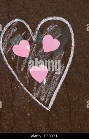 Three pink hearts inside big one painted on rusty metal. Stock Photo