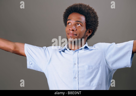 Portrait of young african man with open arms looking up Stock Photo