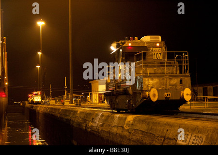 Panama Canal mules helping center a ship at Pedro Miguel Locks, night shot. Panama City, Republic of Panama, Central America. Stock Photo