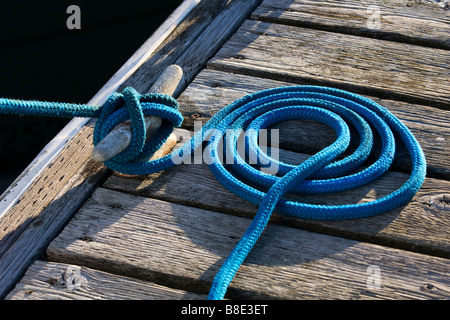 A cleat and mooring line on a dock. Stock Photo