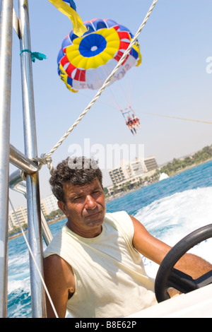 Captain of the parasailing boat with parachute on background. Cyprus Beach. Stock Photo