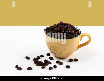 Coffee cup filled with coffee beans Stock Photo