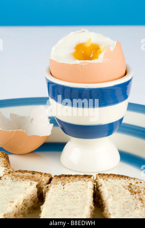 A boiled egg and buttered bread fingers or soldiers Stock Photo