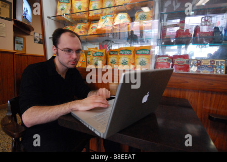 Young man with wireless laptop connection in cafe Italia Montreal Stock Photo