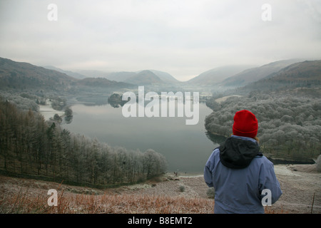 A walker resting admiring the view of Grasmere lake from Loughrigg Terrace in the English Lake District Stock Photo