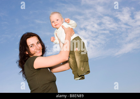 Happy mother 32 years old holding her baby girl 9 months old outside Stock Photo