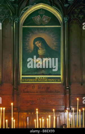 Candles at Polish painting of Virgin Mary of Ostra Brama at St Séverin Church ambulatory in Paris France Stock Photo