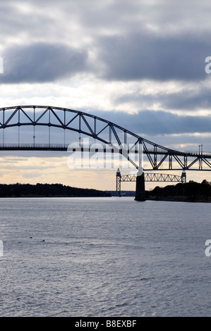 The 'Bourne Bridge' and the 'Cape Cod Canal Railroad Bridge' spanning the 'Cape Cod Canal' on a grey gloomy day. Stock Photo