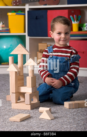 Laughing Boy Building With Wooden Toy Blocks, Vertical Stock Photo