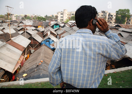 Man speaks on mobile phone in a slum in Kolkata, India Stock Photo