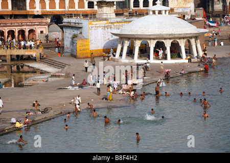 A view on the ghat and people bathing and swimming in Godavari river in Nashik, India Stock Photo