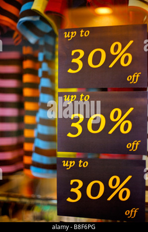 Discount signs on the window of a clothing store close up Stock Photo