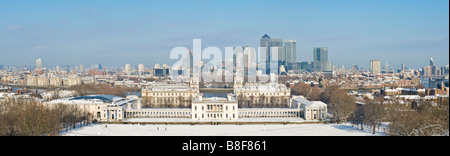 A 3 picture stitch panoramic view from Greenwich Park overlooking Maritime Greenwich and Canary Wharf with snow on the ground. Stock Photo