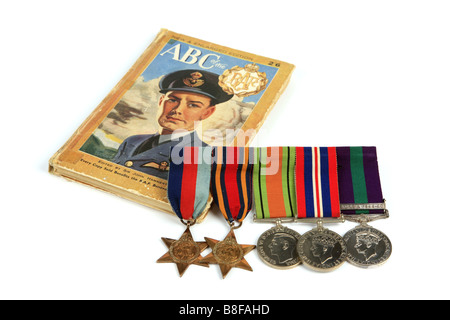A WW2 Recruitment book and a group of British WW2 Medals against a white background Stock Photo