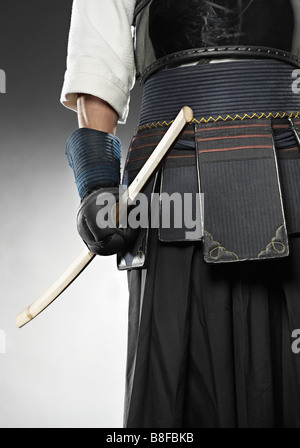 Kendo fighter wearing protective clothing holding katana Stock Photo