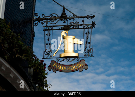 Ornate pub sign hanging outside The Pump House public house against blue sky, The Lanes, Brighton Stock Photo