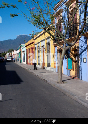 brightly colored houses on the Calle Reforma which ends in a vista of the Sierra Madre del Sur mountains which surround Oaxaca Stock Photo