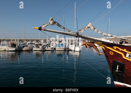 A wooden dolphin hangs beneath the bowsprit of the Flipper Uno tour boat in Los Gigantes marina on Tenerife Canary Islands Spain Stock Photo