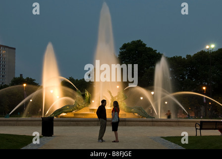 Couple stand in front of Swann Memorial Fountain at dusk, Logan Square, Philadelphia, Pennsylvania. Stock Photo