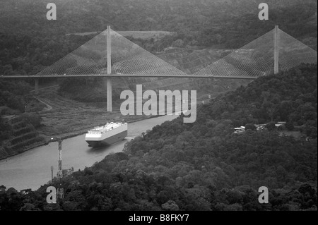 aerial above oil tanker traversing the Gaillard Cut at Centennial Bridge where Pan-American highway crosses Panama Canal Stock Photo