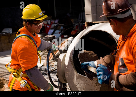 workers preparing mortar using a mixer in a construction site Stock Photo