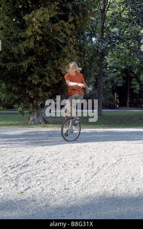 Blonde Boy on an Unicycle - Legerdemain - Youth - Leisure Time - Park Stock Photo