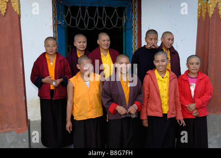 Nine young Buddhist nuns stand outside the entrance to their  newly renovated and extended nunnery near Trashigang. Stock Photo