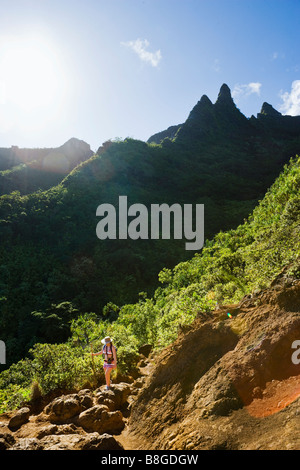 A woman hiking the Na Pali coast of Kauai Hawaii on the Kalalau Trail Stock Photo
