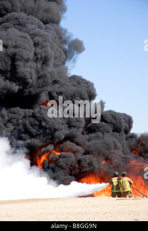 Firefighters using fire retardant foam to put out a jet fuel fire at an airport training facility in Boise Idaho USA Stock Photo