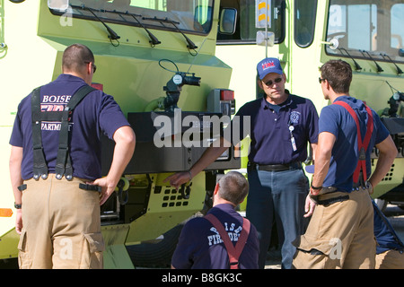 Firefighters taking direction from a training officer at an airport training facility in Boise Idaho USA Stock Photo