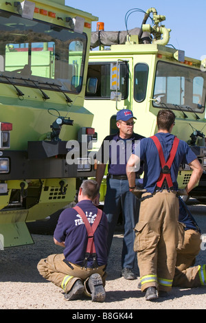 Firefighters taking direction from a training officer at an airport training facility in Boise Idaho USA Stock Photo