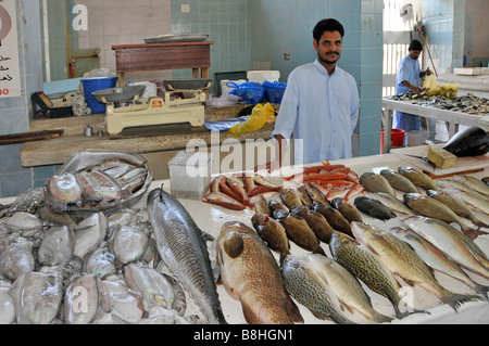 Fish displays and fishmonger vendors at work in Fujairah fish market Emirate of Fujairah on the east coast of UAE Stock Photo