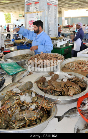 Fish displays and fishmonger vendors at work in Fujairah fish market Emirate of Fujairah on the east coast of UAE Stock Photo