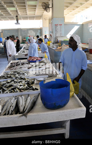 Fish displays and fishmonger vendors at work in Fujairah fish market Emirate of Fujairah on the east coast of UAE Stock Photo