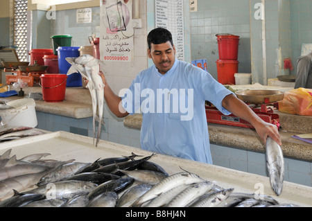 Fish displays and fishmonger vendors at work in Fujairah fish market Emirate of Fujairah on the east coast of UAE Stock Photo