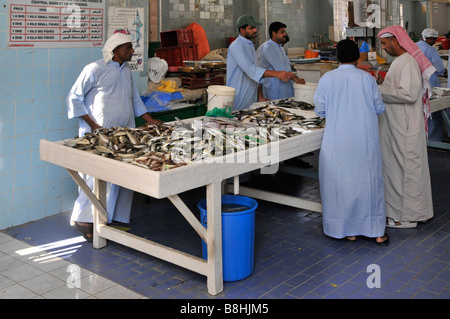 Fish displays and fishmonger vendors at work in Fujairah fish market dominated by men Emirate of Fujairah on the east coast of UAE Stock Photo