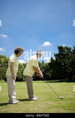 Senior couple playing golf outdoors Stock Photo