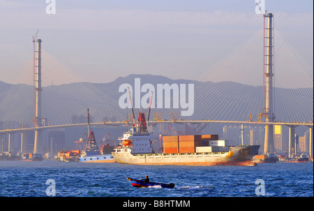 Container ships and Stonecutters bridge which will be the longest of its type in the world, Hong Kong, China. Stock Photo