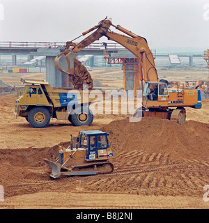 Huge earth-moving machines distribute consolidating material around the French Channel Tunnel Terminal site at Coquelles. Stock Photo