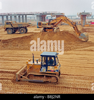 Huge earth-moving machines distribute consolidating material around the French Channel Tunnel Terminal site at Coquelles. Stock Photo